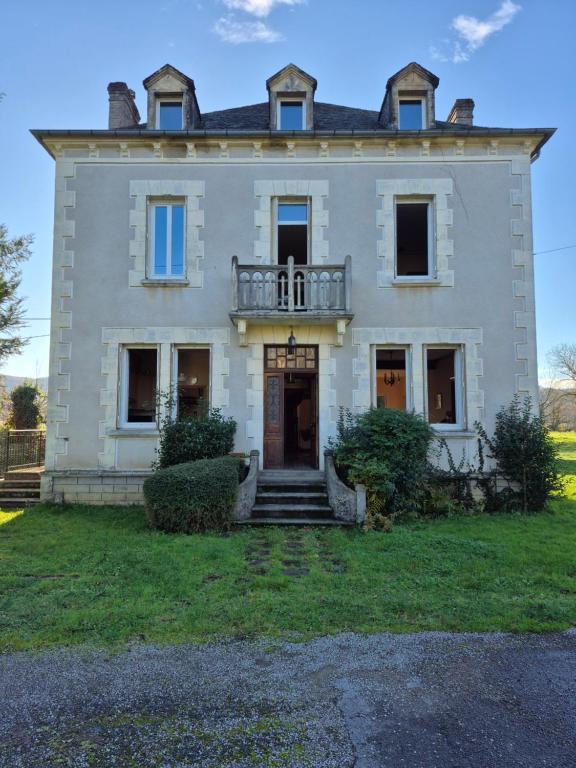 a large white house with a balcony on top at Au Moulin de Gary in Saint-Laurent-les-Tours