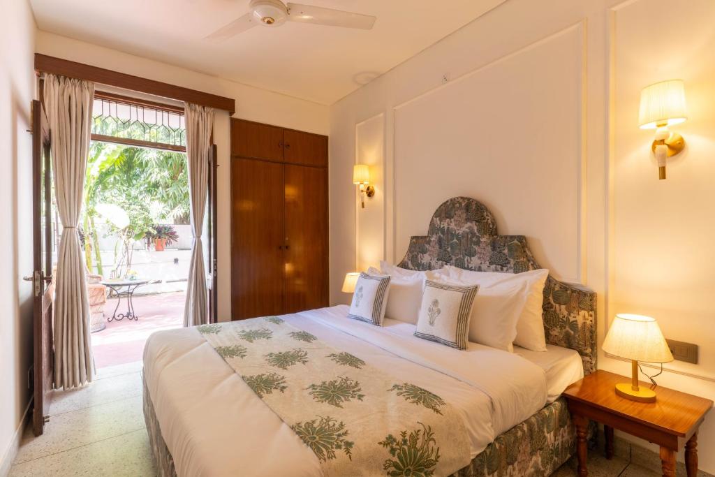 een slaapkamer met een bed en een groot raam bij Jobner Haus Jaipur in Jaipur