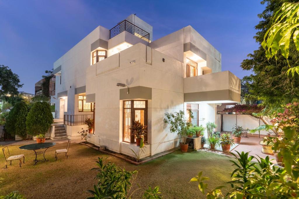 a large white house with a table in a yard at Jobner Haus Jaipur in Jaipur