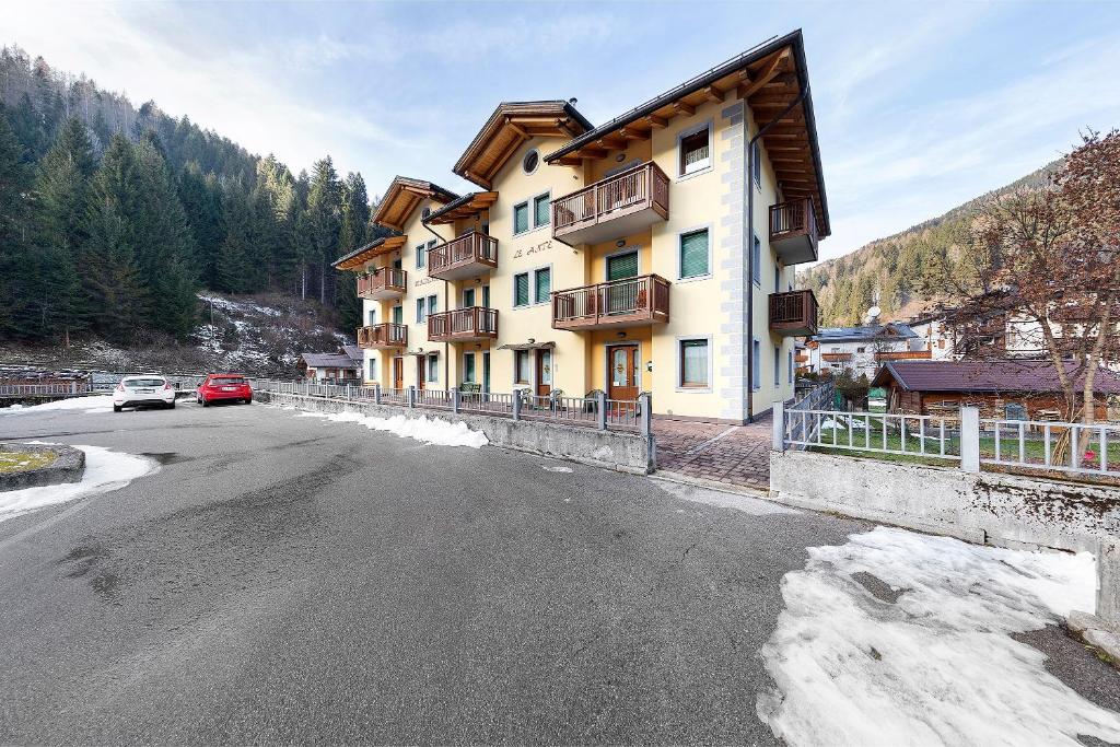 ein Gebäude am Straßenrand mit einem Auto in der Unterkunft Residence Le Ante - Cadore in Santo Stefano di Cadore