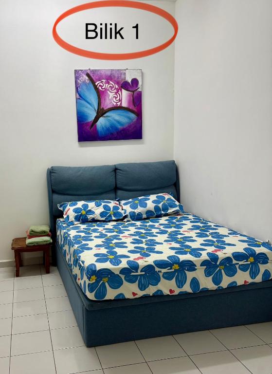 a bedroom with a bed with a blue bedspread at HOMESTAY CIKGU NORa near UTHM KPTM KKTM IPG Moslim onli in Kampong Seri Gading