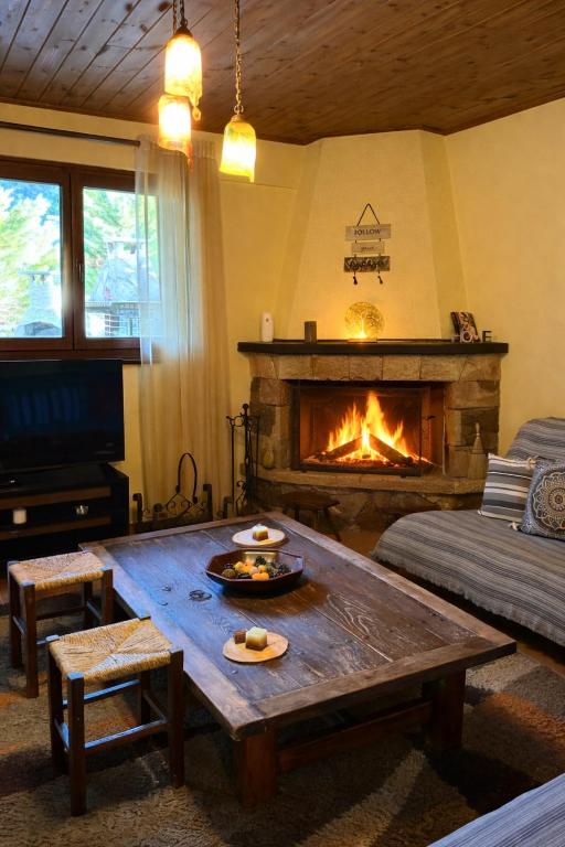 een woonkamer met een tafel en een open haard bij Horizon Nest Parnassos Villa Chalet! in Eptalofos