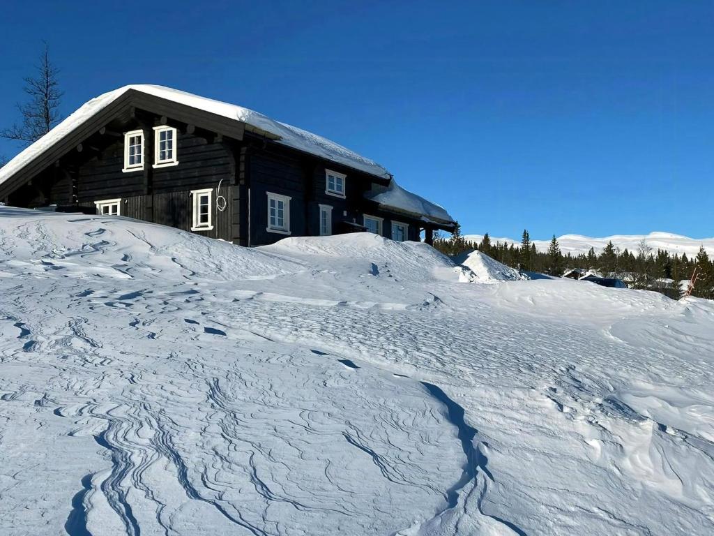 ein Haus auf einem schneebedeckten Hang in der Unterkunft Cabin With Panoramic View In Synnfjell in Nord Torpa