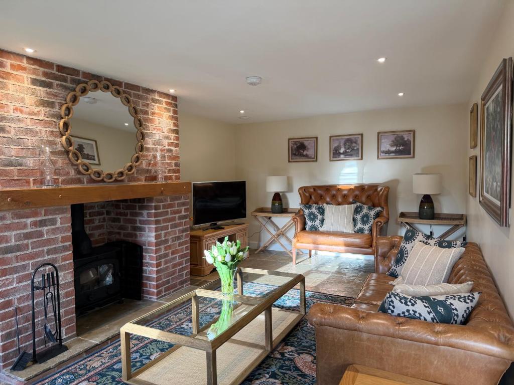 a living room with a couch and a fireplace at Meadow View House at Pudleston Court in Docklow