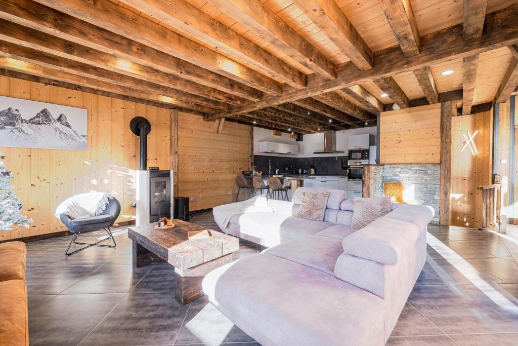 ein Wohnzimmer mit weißen Sofas und einem Kamin in der Unterkunft Chalet Saint Sorlin in Saint-Sorlin-dʼArves