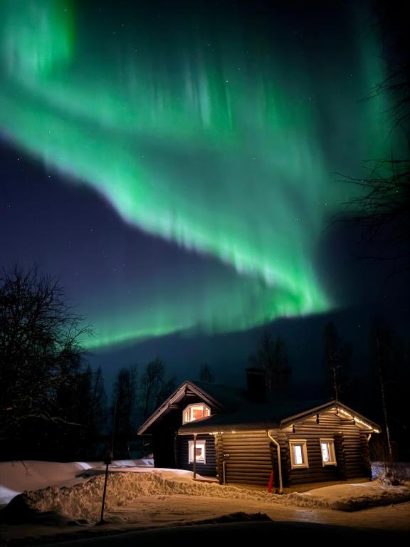 an image of the aurora borealis above a cabin at Villa Hackberry Hill in Rovaniemi