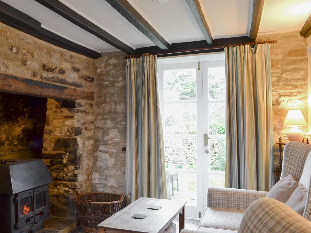 ein Wohnzimmer mit einem Kamin und einer Steinmauer in der Unterkunft Mulberry Cottage - 27905 in Langton Matravers