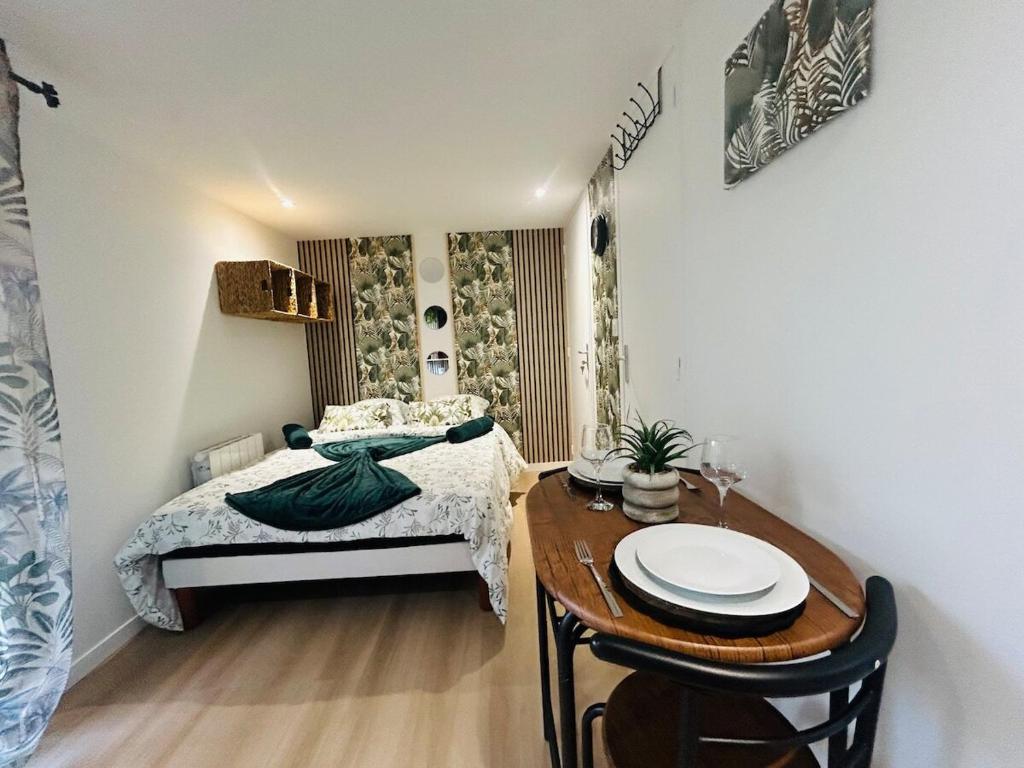 ein kleines Schlafzimmer mit einem Bett und einem Tisch in der Unterkunft Casa Tropical in Les Ponts-de-Cé