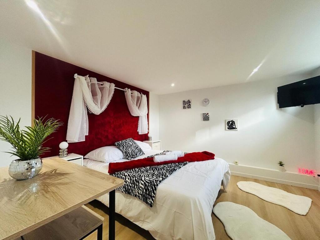 a bedroom with a bed with a red headboard at Casa Rubis in Les Ponts-de-Cé