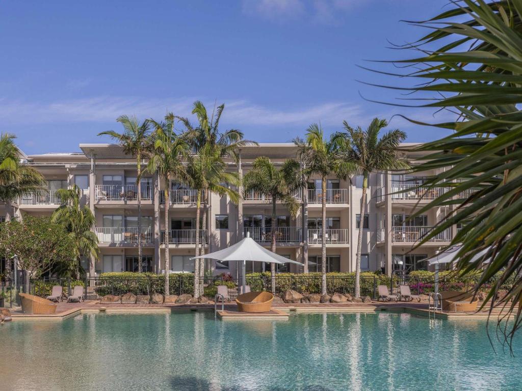 a resort with a swimming pool and palm trees at Peppers Salt Resort & Spa in Kingscliff
