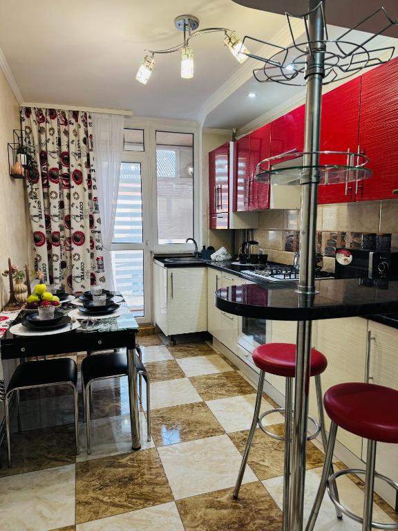 una cucina con mobili rossi, tavolo e sedie di Центр. Хмельницького. 2 спальні a Ternopilʼ