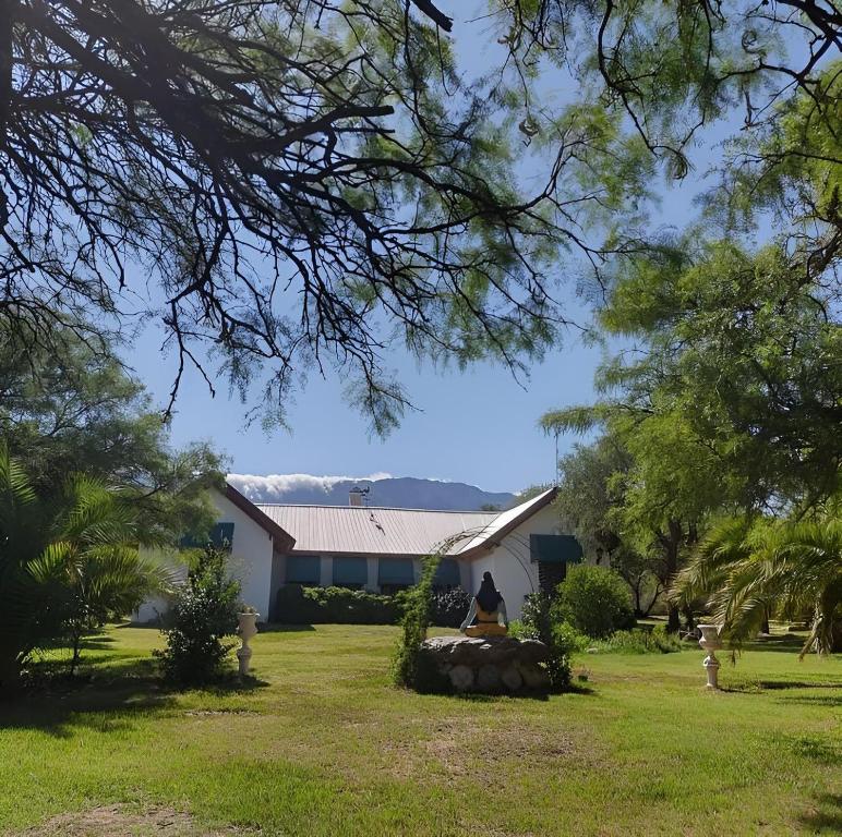 Eine Frau, die vor einem Haus sitzt. in der Unterkunft White Field Houses and Spa in Villa Las Rosas