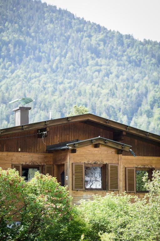 a wooden house with a mountain in the background at Scharnitz Chalet - gut eingerichtetes Haus in Scharnitz