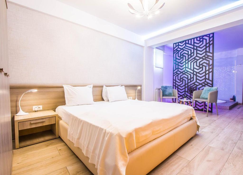 Un dormitorio con una cama grande y una mesa y sillas. en Parliament Square, en Bucarest