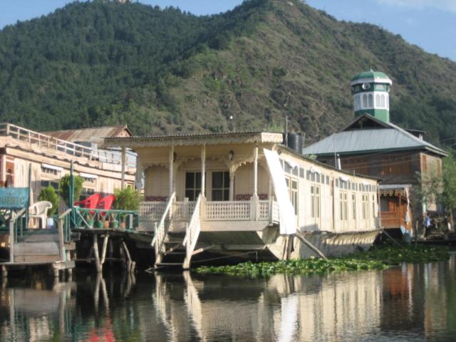 a house on a dock on a body of water at Houseboat Quebec in Srinagar
