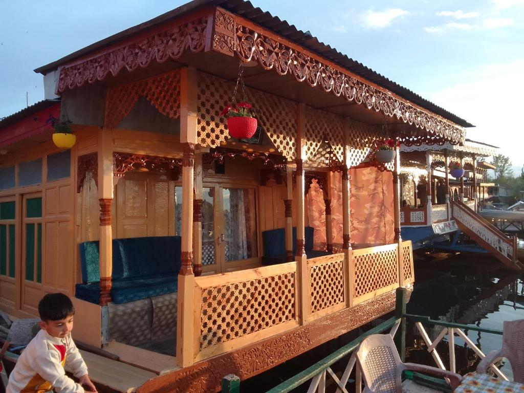 a little boy standing in front of a house on a boat at Houseboat Quebec in Srinagar