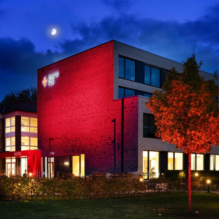 a red brick building with a tree in front of it at DRK-Tagungshotel-Dunant in Münster