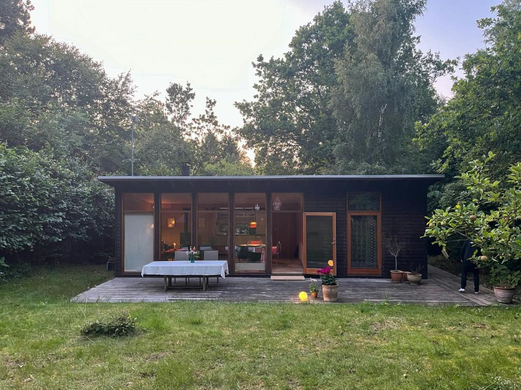 una pequeña casa con una mesa de picnic en el patio en Architect-Designed Wooden House In Tisvilde Lunde, en Tisvildeleje