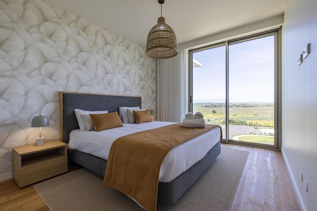 a bedroom with a large bed with a large window at Bayline XV in Armação de Pêra