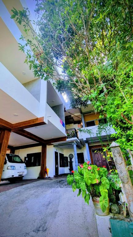 a building with a bunch of plants in front of it at Namal Stay in Weligama