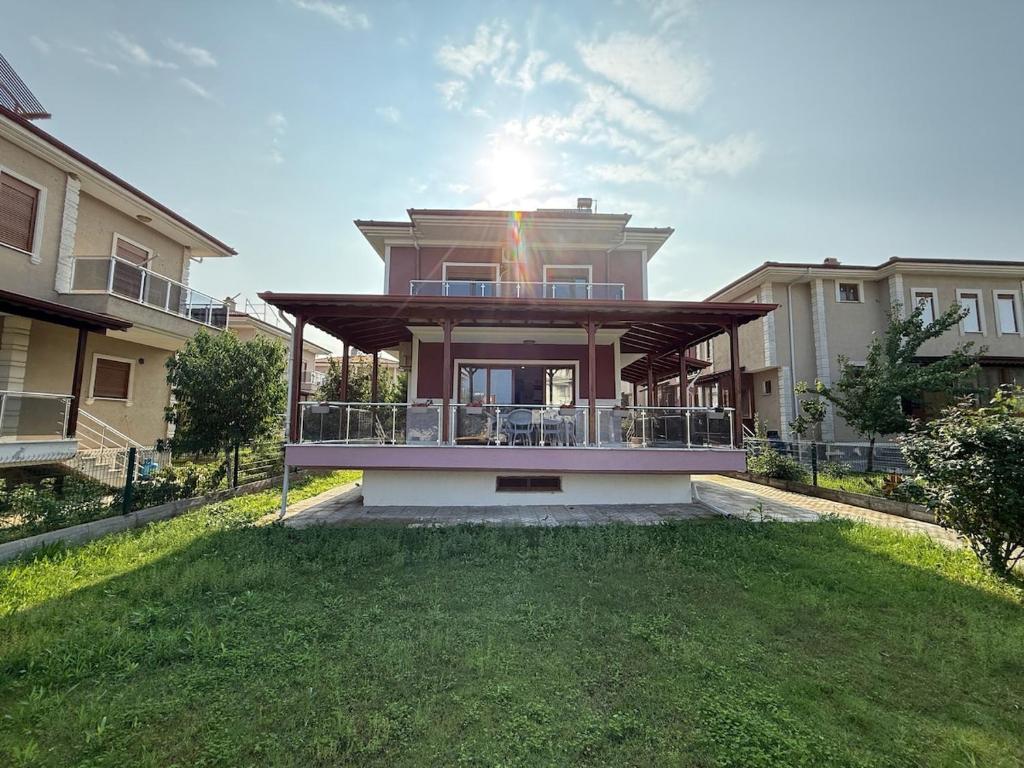 una grande casa con balcone in cima a un cortile di Family Duplex Villa with Garden 150m to Beach a Ayvalık