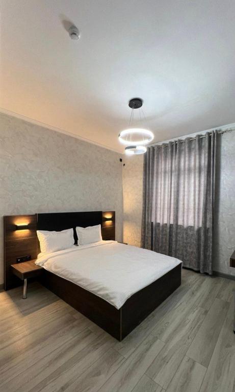 a bedroom with a large bed and a large window at Van park hotel in Shymkent