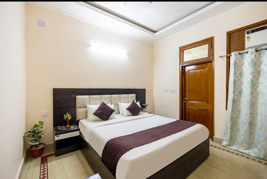 um quarto com uma cama grande em um quarto em Hotel Emerald Suites & Banquet By Aura em Noida
