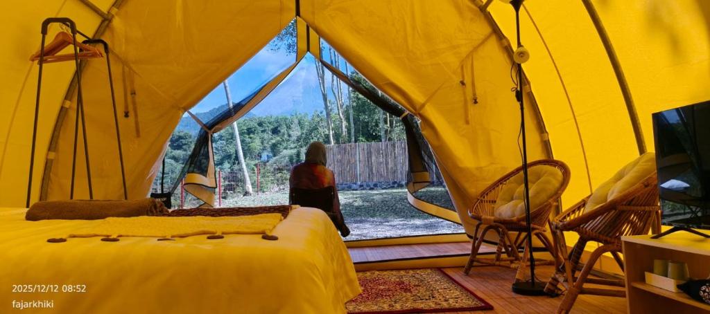 una camera con letto e finestra in una tenda di Kayi glamping a Kaliurang