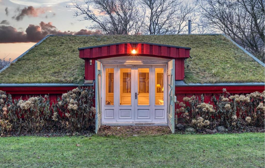 ein Haus mit einem Grasdach und einer weißen Tür in der Unterkunft Gorgeous Home In Galmsbüll in Galmsbüll