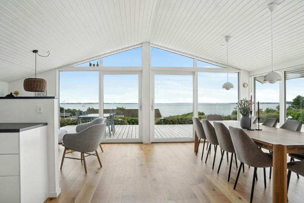 a kitchen and dining room with a table and chairs at Newly Renovated Holiday Home With Aarhus Bay Views in Rønde