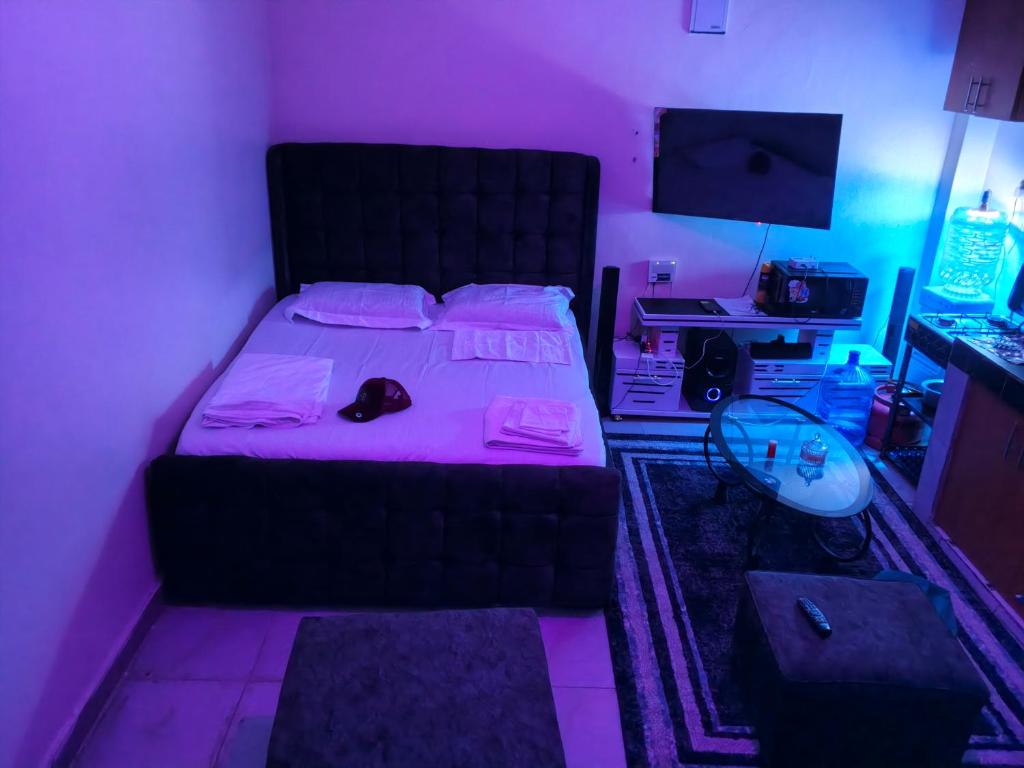 een slaapkamer met een bed met een paars licht bij Goshen heights in Kitengela 