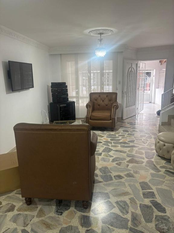 een woonkamer met een bank en een stoel bij Casa en Rincón de Los Prados in Cúcuta
