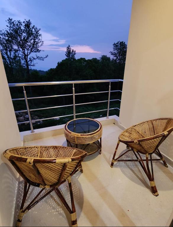 two chairs and a fire pit on a balcony at Coffee valley resort Yercaud CVR in Yercaud