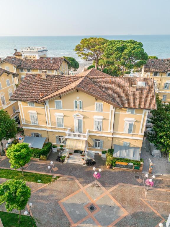 an aerial view of a large yellow house with the ocean at Residence Villa Spiaggia in Grado