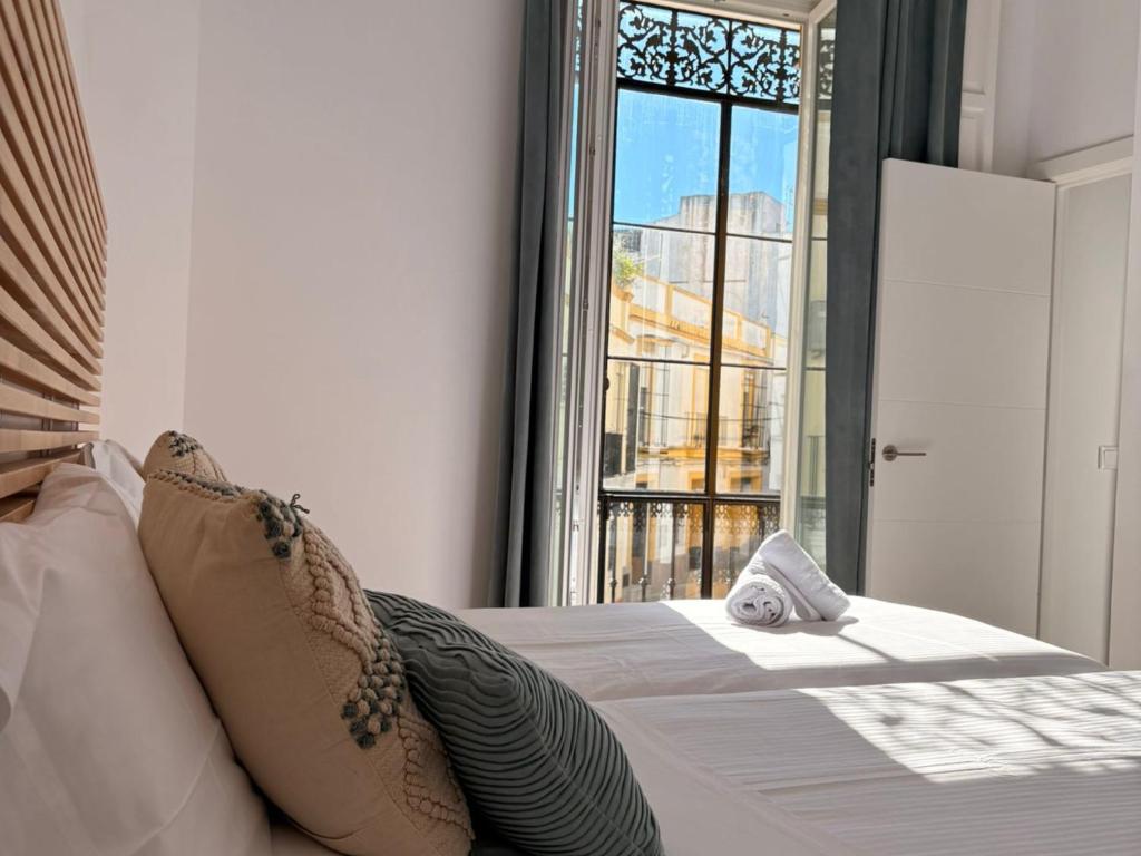 a bedroom with a bed with a large window at Life Apartments Arcos 27 in Jerez de la Frontera