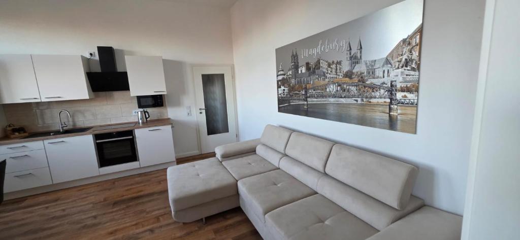 a living room with a couch and a kitchen at FewoNr9 in Magdeburg