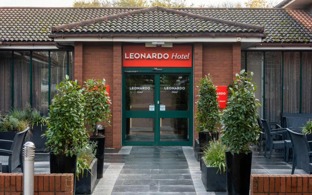 un edificio de ladrillo rojo con una puerta verde en Leonardo Hotel East Midlands Airport, en Castle Donington