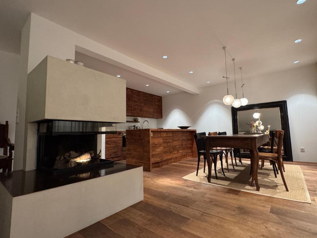 a kitchen and dining room with a table and a fireplace at Apartment Chalet Ambros in Lech am Arlberg