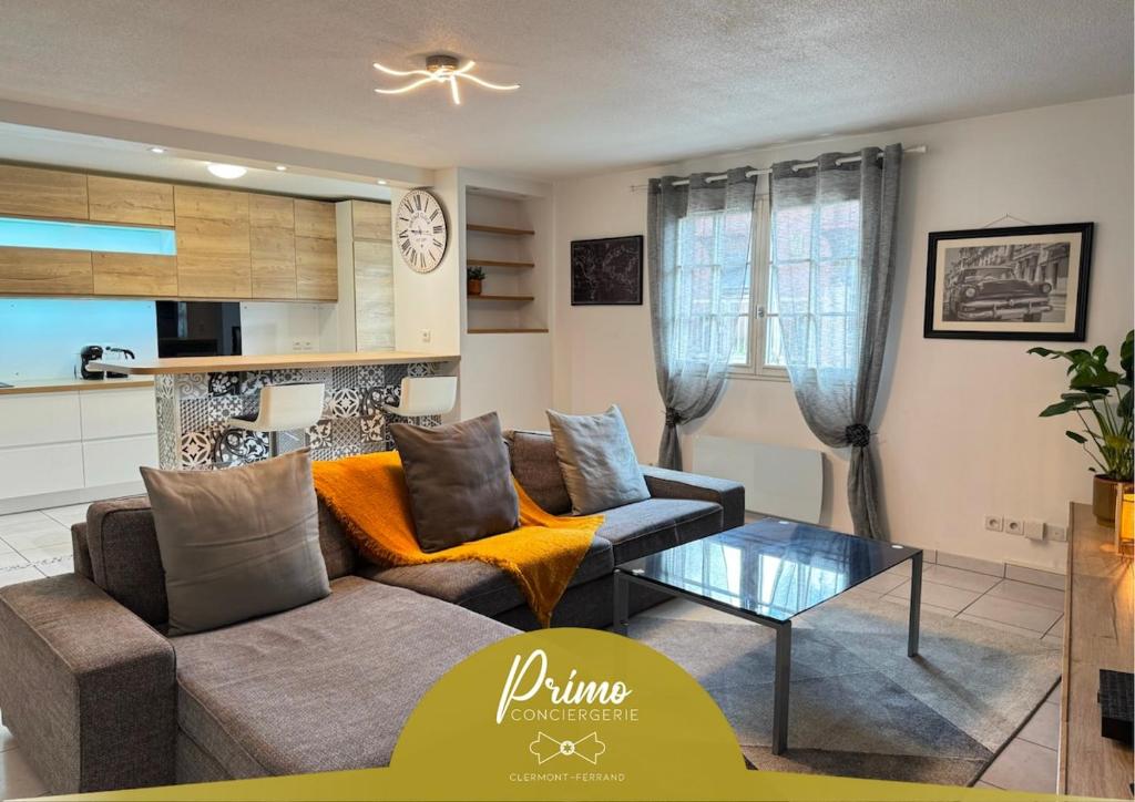 een woonkamer met een bank en een tafel bij Rives Bleues by PRIM0 C0NCIERGERIE in Pont-du-Château