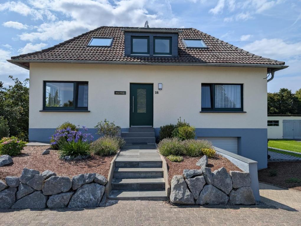 ein weißes Haus mit grüner Tür in der Unterkunft Ferienhaus MAWO 4 Sterne in Andernach