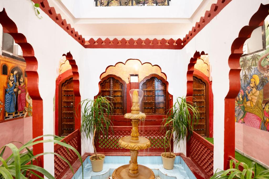 een fontein in de lobby van een gebouw met schilderijen bij Stamps By Eight Continents, Pushkar in Pushkar