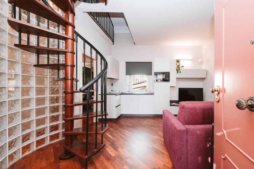 a living room with a spiral staircase and a red couch at Evi Suite in Santa Margherita Ligure