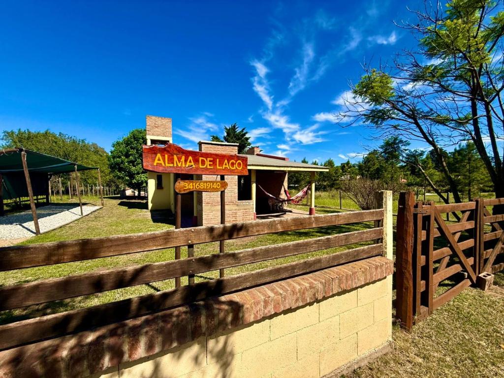 una recinzione di fronte a un edificio con un cartello di Alma de Lago a Villa Rumipal