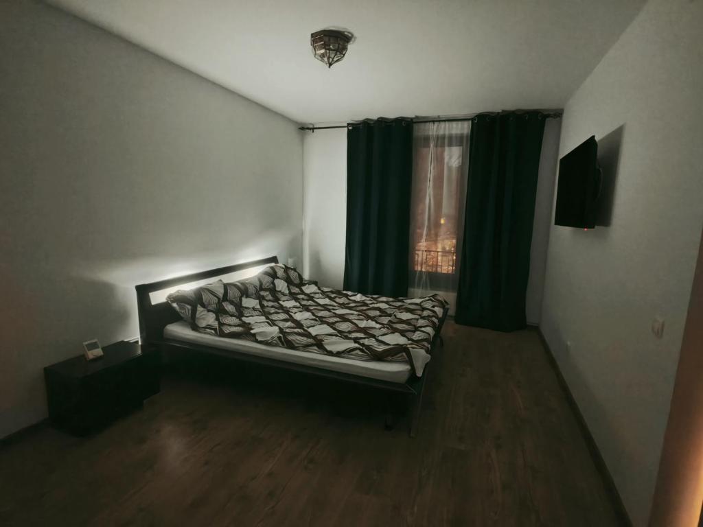 Schlafzimmer mit einem Bett und einem Fenster mit grünen Vorhängen in der Unterkunft Apartament ultracentral Ștefan cel mare in Craiova