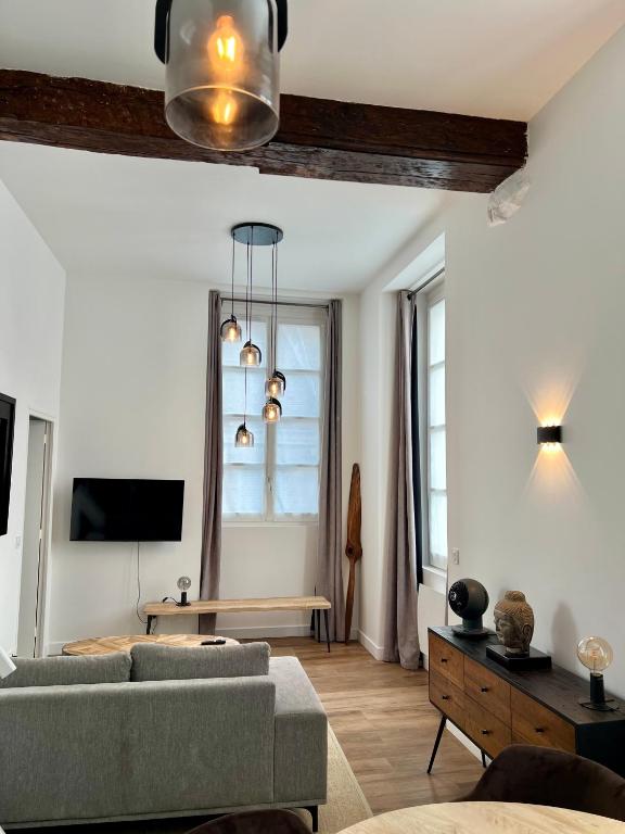 a living room with a couch and a table at Le Laurencin Sens - Le cocon - Cœur de ville in Sens