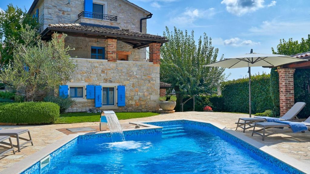 a swimming pool in front of a house at Rustic Villa Simone with outdoor pool in Porec in Krmenjak