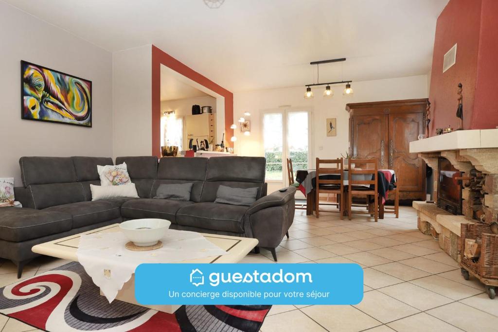 un salon avec un canapé et une table dans l'établissement L'écrin sous les chênes - Wifi - Jardin, à Olivet