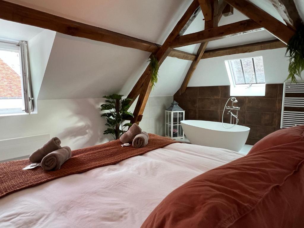 a bedroom with a bed and a bath tub at Le Laurencin Sens - Le Duplex - Cœur de ville in Sens