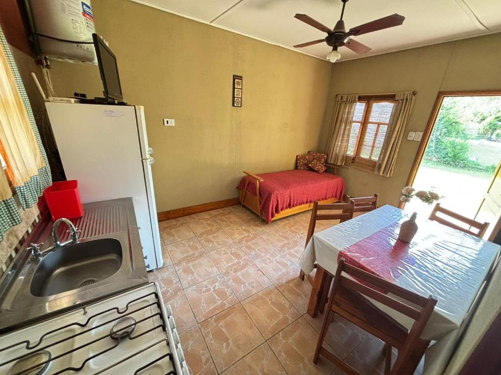 una cucina con lavandino, frigorifero e tavolo di Las Casitas De Moni a Villa del Dique