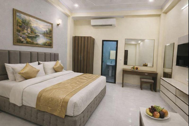 een hotelkamer met een groot bed en een bureau bij Hotel Vegas Corporate Suites By Aura in Noida